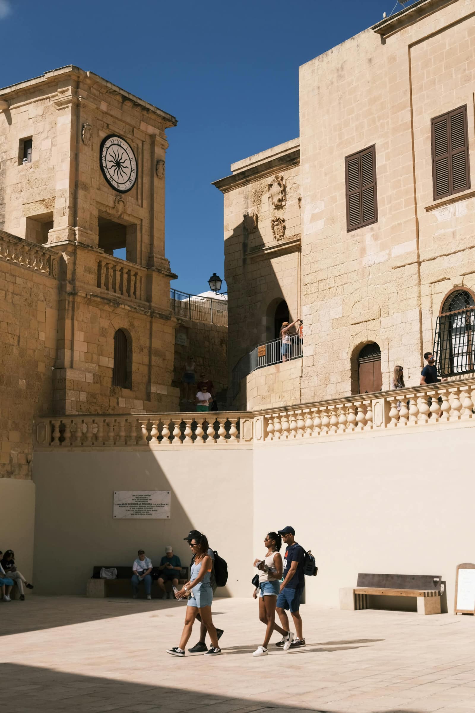Students walking through a sunlit square in Malta